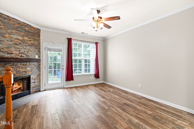 unfurnished living room with ornamental molding, hardwood / wood-style floors, a stone fireplace, and ceiling fan