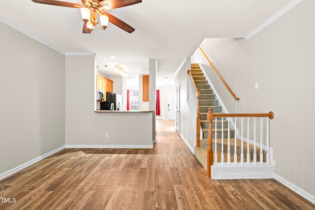 unfurnished living room featuring ornamental molding and hardwood / wood-style flooring