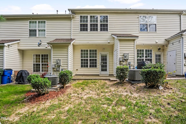 rear view of property with a lawn and central AC unit