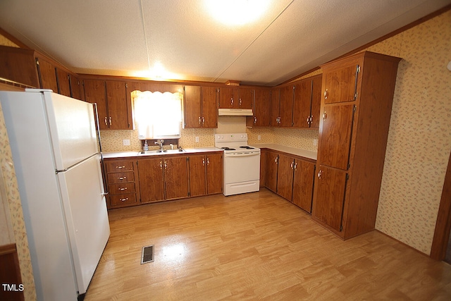 kitchen with a textured ceiling, light wood-type flooring, sink, and white appliances