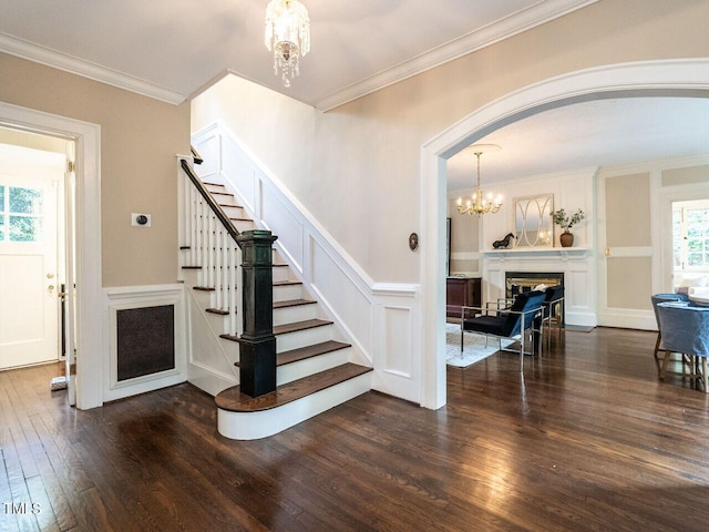 2501 Kenmore Dr, Raleigh, NC 27608 - staircase with arched walkways, a notable chandelier, crown molding, and wood-type flooring