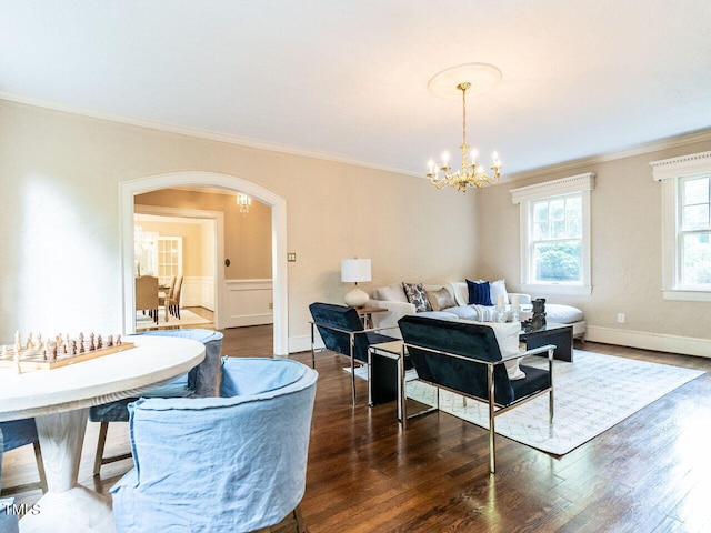 dining area with ornamental molding, a notable chandelier, and dark hardwood / wood-style flooring