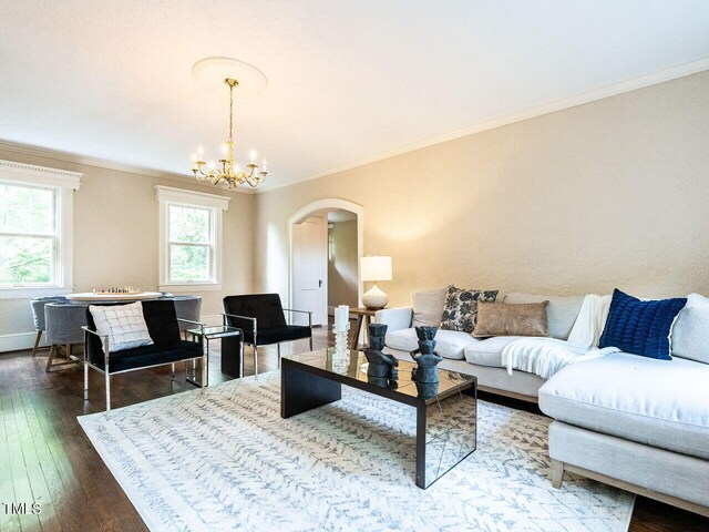 2501 Kenmore Dr, Raleigh, NC 27608 - living room featuring hardwood / wood-style flooring, crown molding, arched walkways, and a chandelier