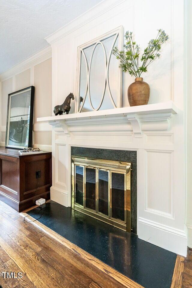 2501 Kenmore Dr, Raleigh, NC 27608 - interior details with a glass covered fireplace, crown molding, and wood finished floors