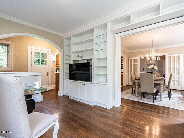 living room with ornamental molding, dark hardwood / wood-style floors, and a chandelier