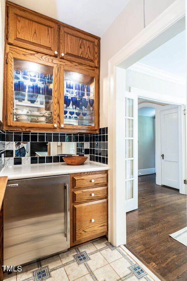 kitchen with light hardwood / wood-style flooring, backsplash, and ornamental molding