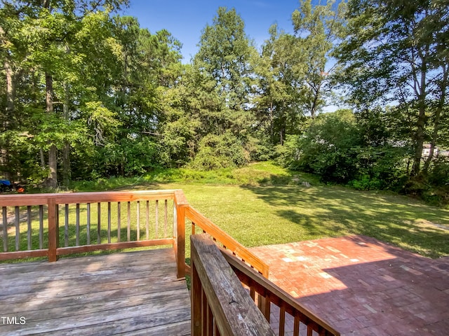 wooden terrace with a lawn and a patio area