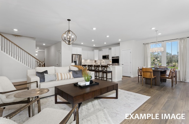 living room featuring hardwood / wood-style flooring, an inviting chandelier, and sink