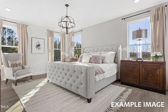 bedroom with light wood-type flooring and a chandelier