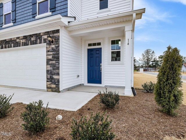 doorway to property with stone siding and an attached garage