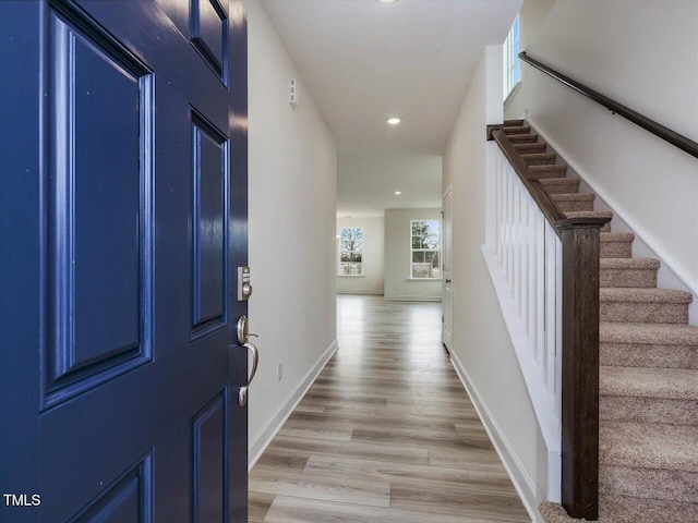 entrance foyer with recessed lighting, stairway, baseboards, and light wood-style flooring