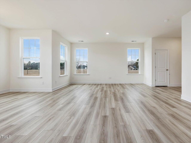 empty room with recessed lighting, light wood-style floors, and baseboards