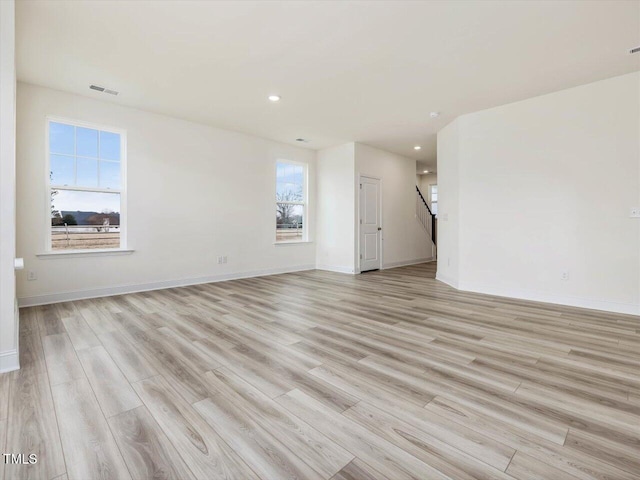 unfurnished room featuring visible vents, baseboards, and light wood finished floors