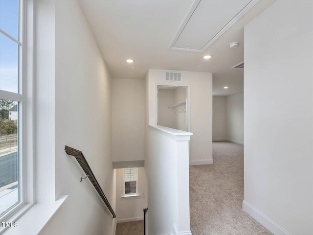 stairs with visible vents, attic access, baseboards, and carpet floors