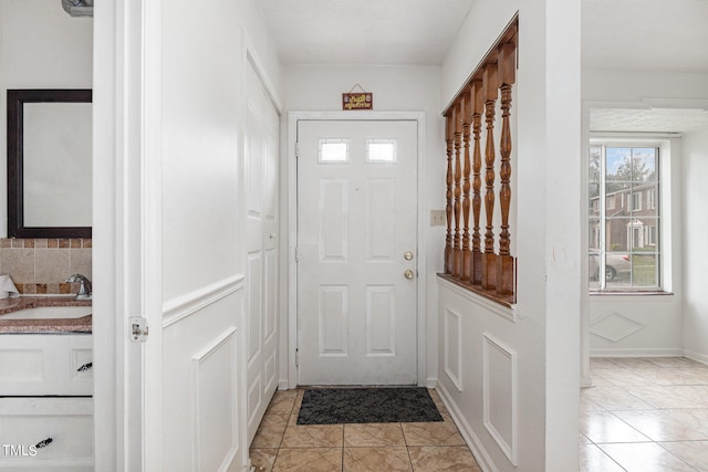 entryway featuring light tile patterned floors and sink