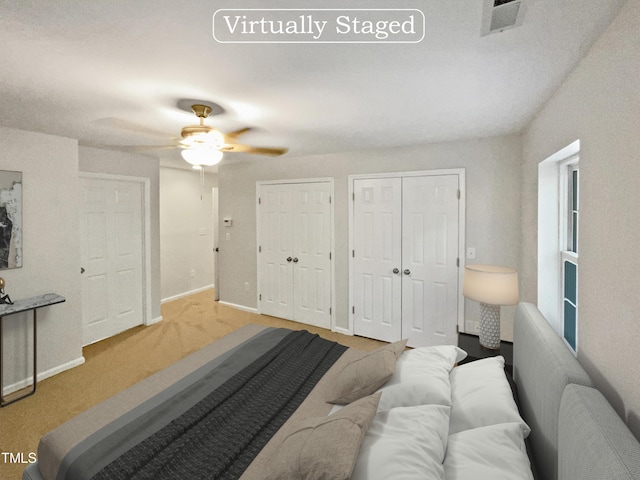 bedroom featuring baseboards, multiple closets, visible vents, and a ceiling fan