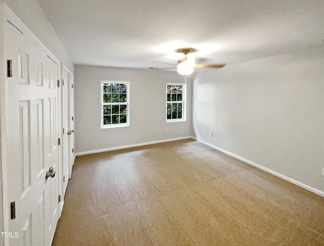 unfurnished room featuring a ceiling fan, carpet, and baseboards