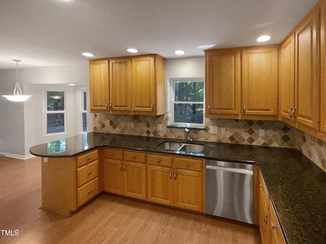 kitchen featuring dishwasher, light wood-type flooring, a peninsula, and a sink