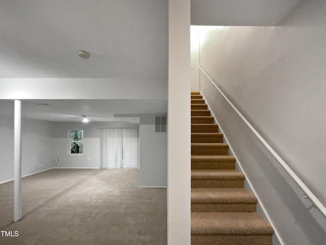 staircase with visible vents, carpet flooring, and baseboards