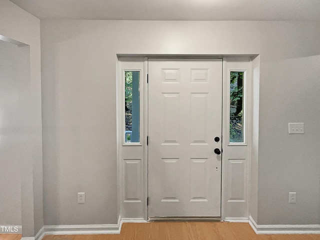 entrance foyer with baseboards, a healthy amount of sunlight, and light wood finished floors