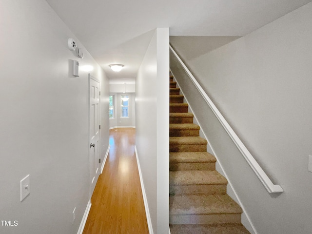 stairway with baseboards and wood finished floors