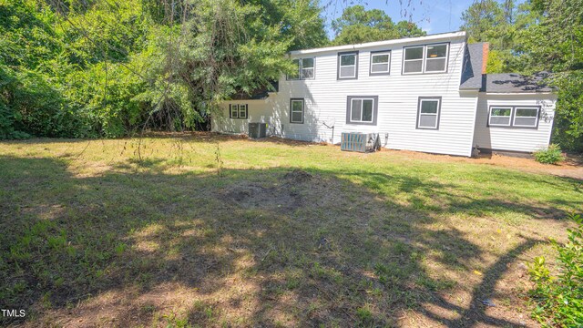 back of property with a lawn and central AC unit