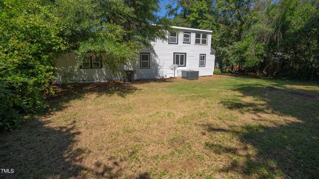 back of property with a lawn and cooling unit