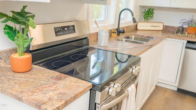 kitchen with sink, stainless steel appliances, light hardwood / wood-style floors, and white cabinetry