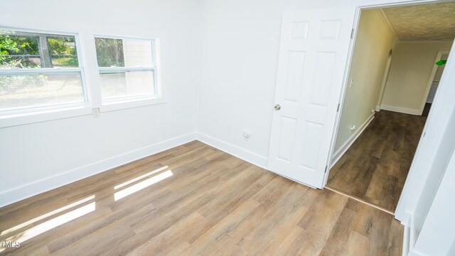 spare room with ornamental molding and wood-type flooring