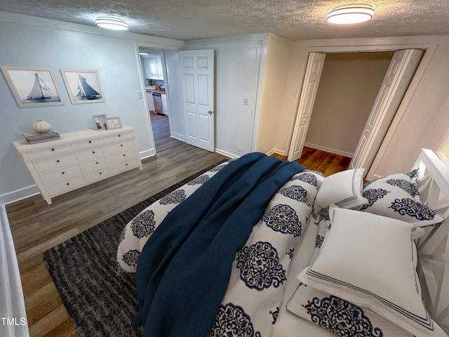 bedroom featuring a textured ceiling, dark wood-type flooring, and a closet