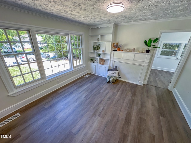 interior space with a textured ceiling, dark hardwood / wood-style floors, and ornamental molding