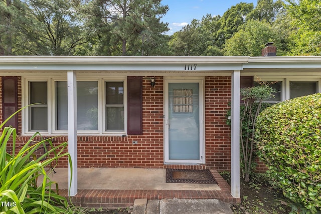 doorway to property with brick siding