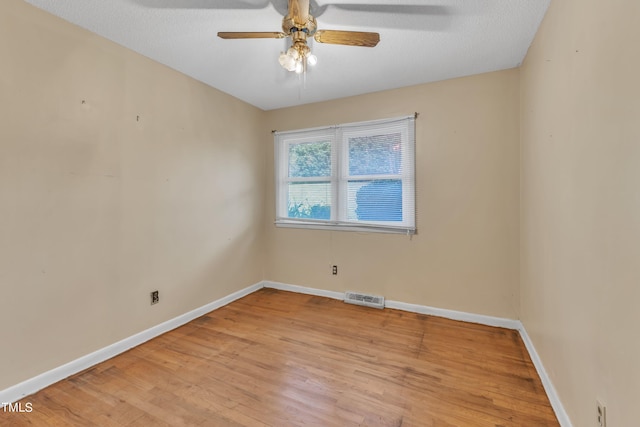 empty room with baseboards, visible vents, and light wood-type flooring