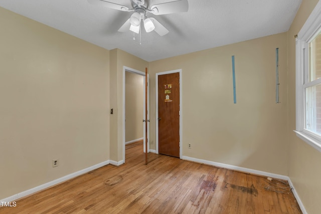 unfurnished bedroom featuring a ceiling fan, light wood-style floors, and baseboards