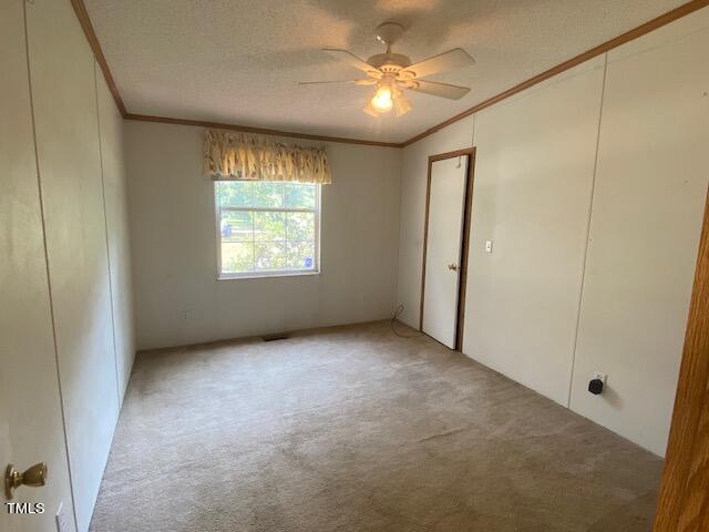 unfurnished bedroom with vaulted ceiling, a textured ceiling, ceiling fan, and carpet floors