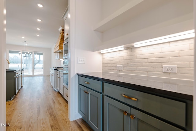 kitchen featuring light wood-type flooring, pendant lighting, tasteful backsplash, recessed lighting, and wall oven