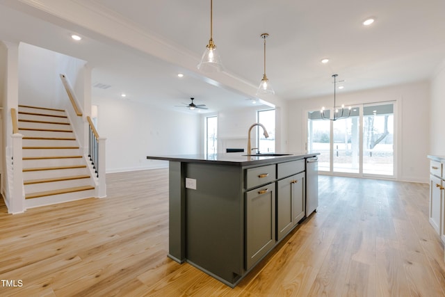 kitchen featuring gray cabinets, a sink, open floor plan, light wood-style floors, and dishwasher