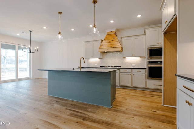 kitchen featuring custom exhaust hood, a sink, decorative backsplash, appliances with stainless steel finishes, and dark countertops