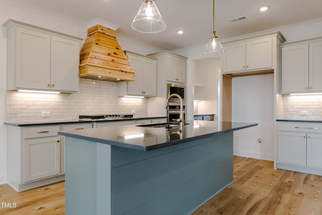 kitchen with stainless steel appliances, dark countertops, visible vents, and custom range hood