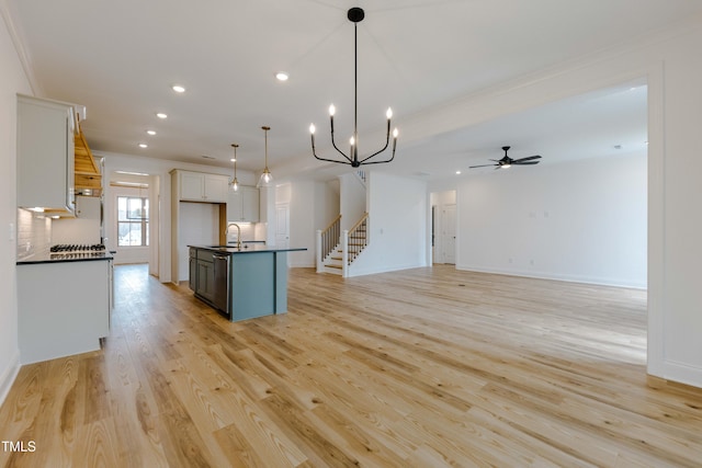 kitchen featuring a sink, light wood-style floors, dark countertops, and white cabinetry