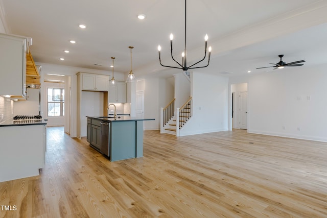 kitchen featuring a sink, dark countertops, stainless steel dishwasher, recessed lighting, and light wood-style floors