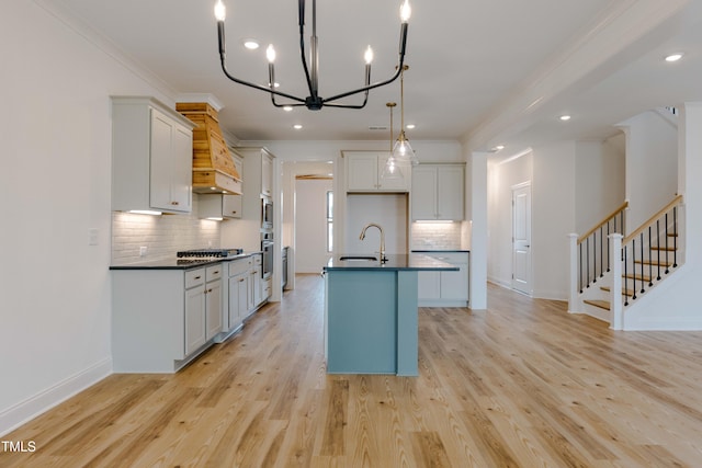 kitchen with dark countertops, light wood-style flooring, appliances with stainless steel finishes, and a sink