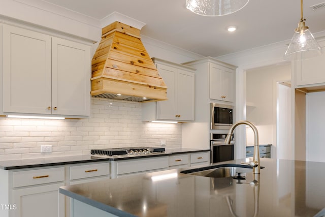 kitchen with dark countertops, ornamental molding, stainless steel gas cooktop, and premium range hood