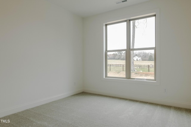 empty room featuring visible vents, baseboards, and light colored carpet