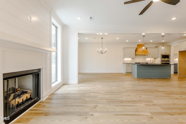 unfurnished living room with a fireplace, light wood-style flooring, and a healthy amount of sunlight