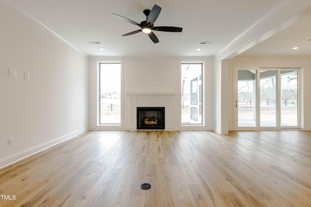 unfurnished living room with visible vents, a healthy amount of sunlight, and light wood-style floors