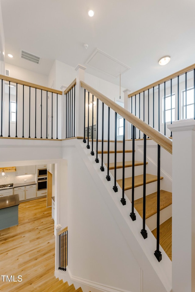 stairway featuring recessed lighting, visible vents, attic access, and wood finished floors