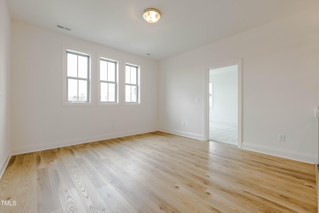 spare room with visible vents, baseboards, and light wood-style flooring