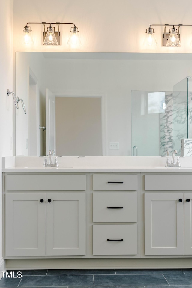 bathroom featuring double vanity, an enclosed shower, and a sink