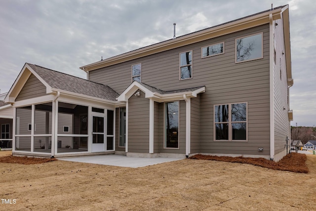 back of house featuring a patio area, roof with shingles, and a sunroom